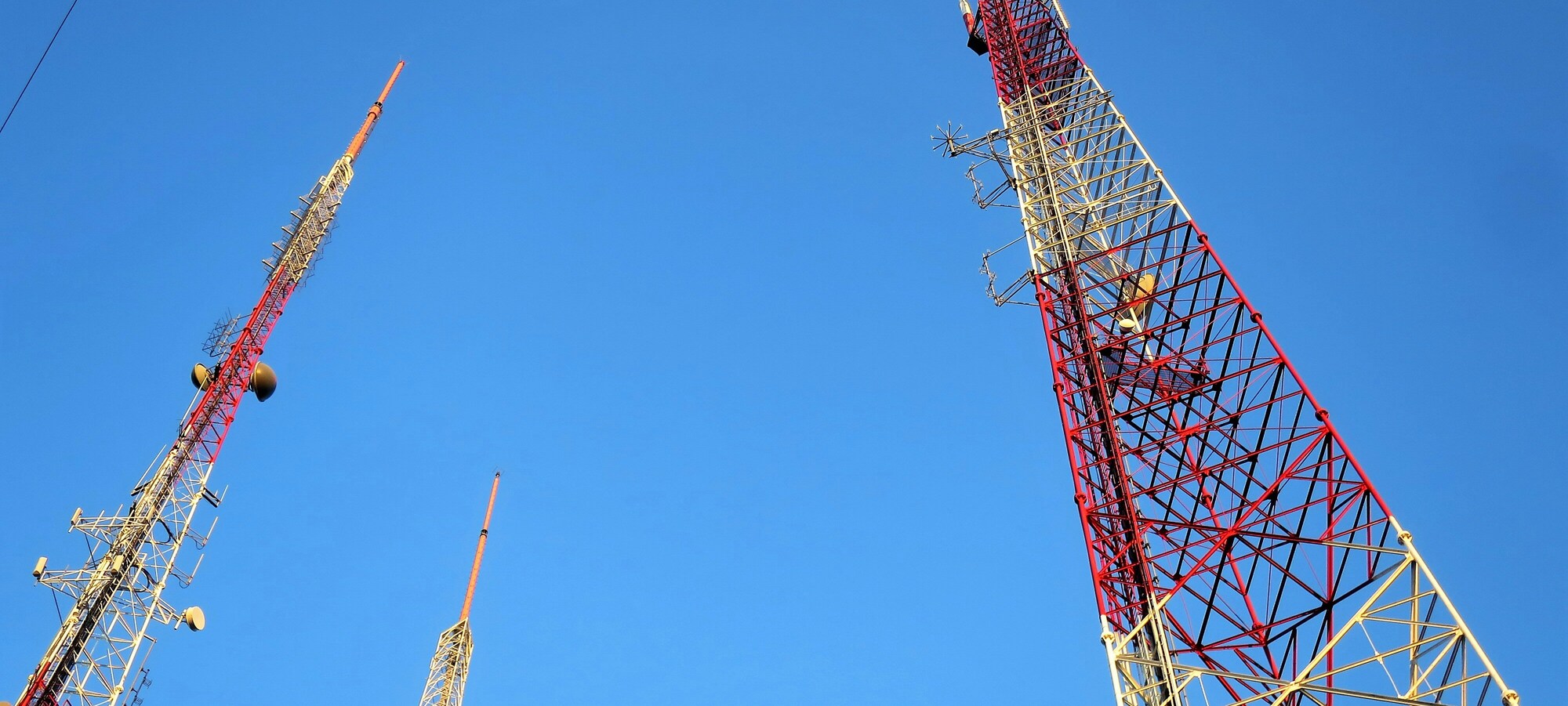 Telecommunications towers against a clear blue sky